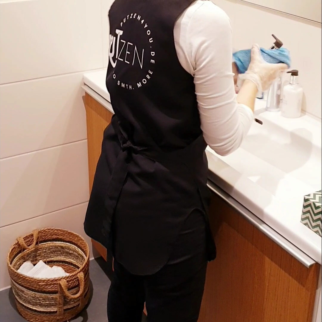 Person cleaning a sink with dry cloth