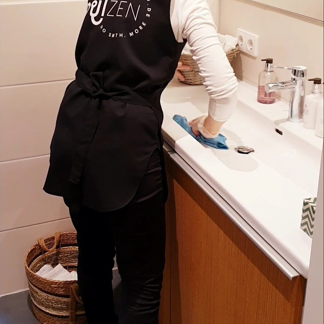 Person cleaning a sink with dry cloth